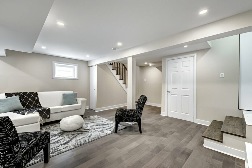 Beautifully remodeled basement with modern lighting, wood floors, and a comfortable seating area.