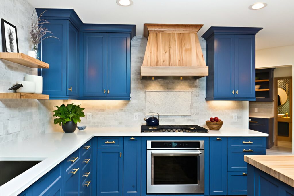 Modern kitchen with blue cabinets, wooden range hood, and white countertops.